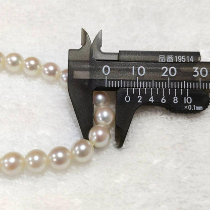 Akoya pearl necklace with 7mm round pearls and silver marking, 36cm length, displayed on white background