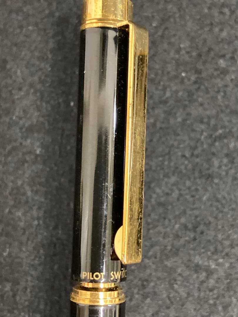 Two PILOT SWITCH black fountain pens with gold-colored accents and plastic bodies displayed side by side