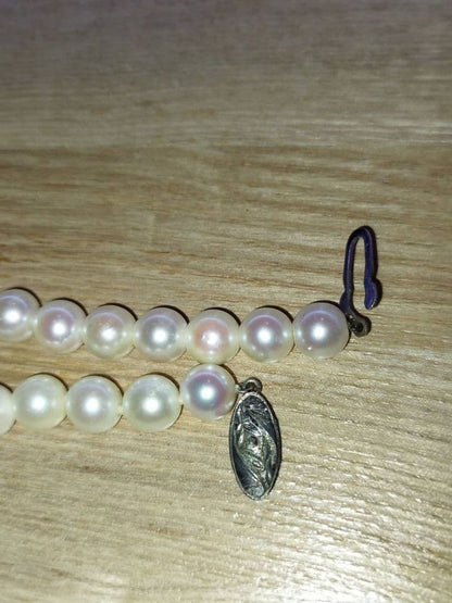 Pearl necklace with white and pink Akoya pearls arranged in a classic strand