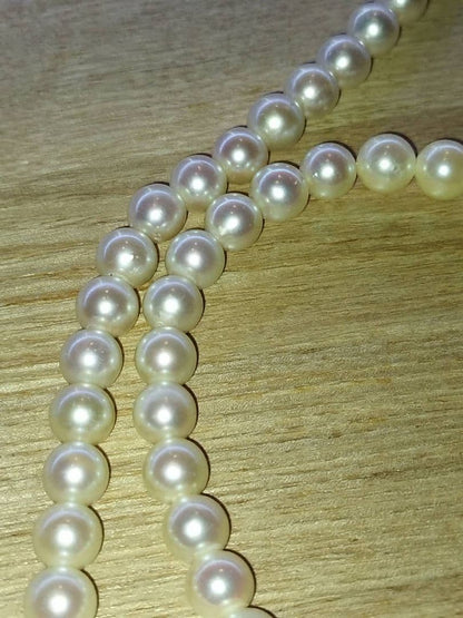Pearl necklace with white and pink Akoya pearls arranged in a classic strand