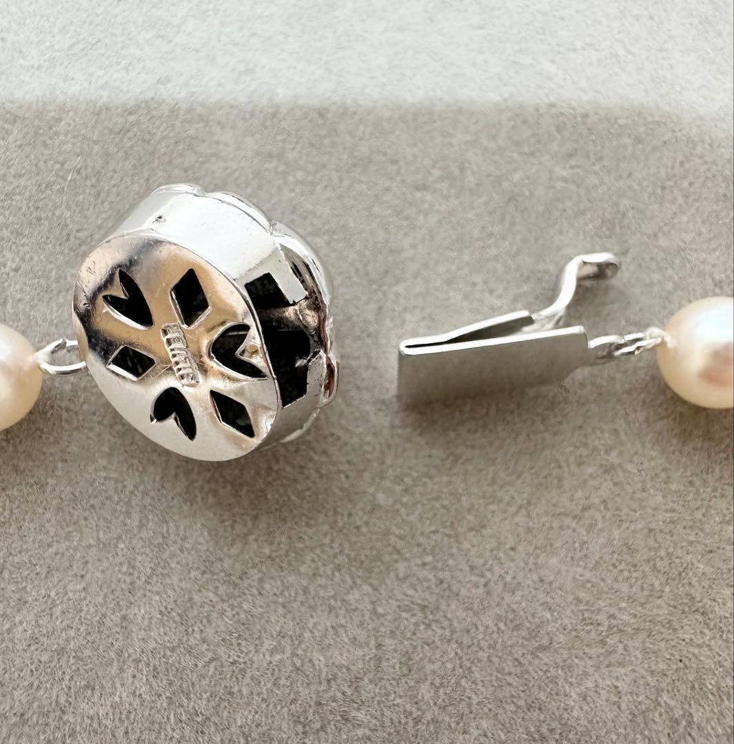 Akoya pearl necklace with 7mm pearls, silver clasp with inscription, displayed with certificate and case