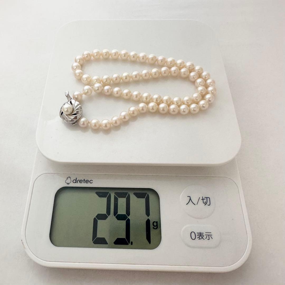 Akoya pearl necklace with 7mm pearls, silver clasp with inscription, displayed with certificate and case
