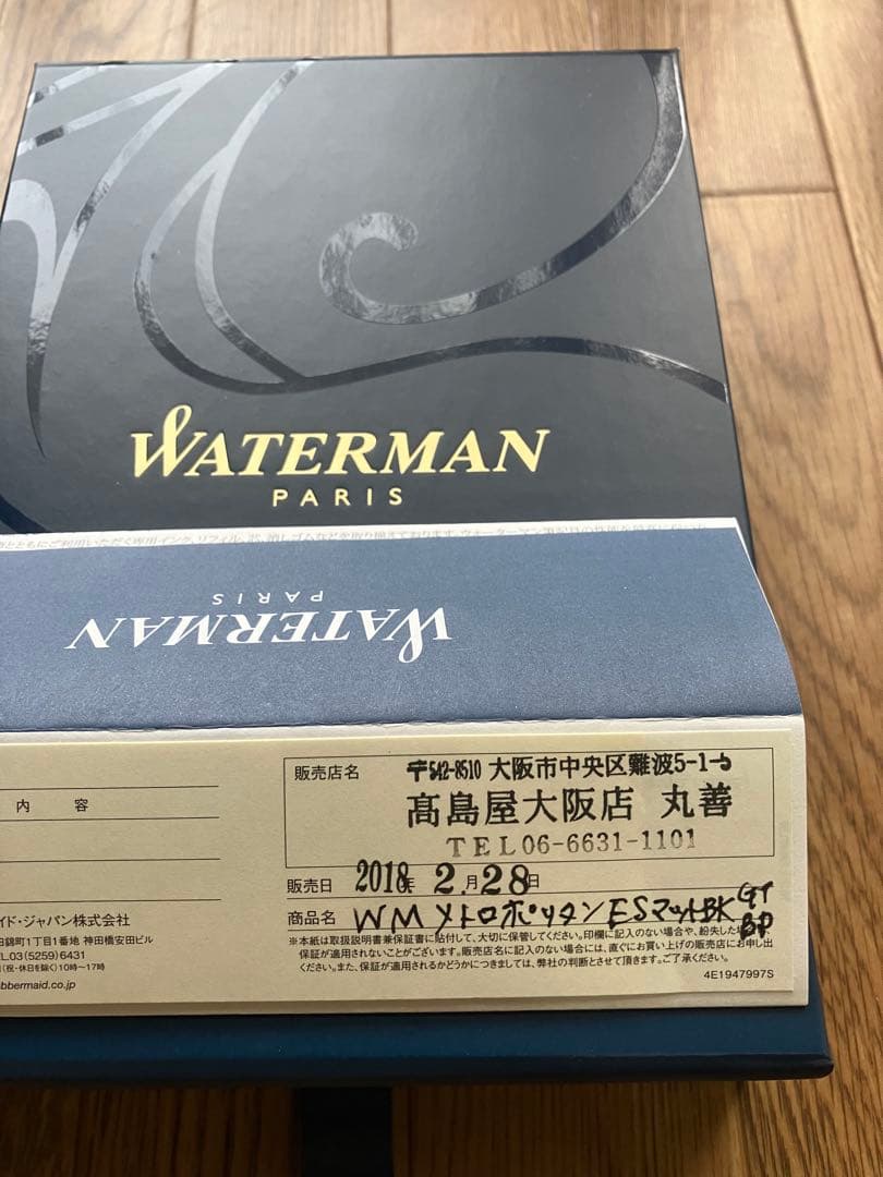Waterman Metropolitan ballpoint pen with matte black body and gold trim lying on a white background