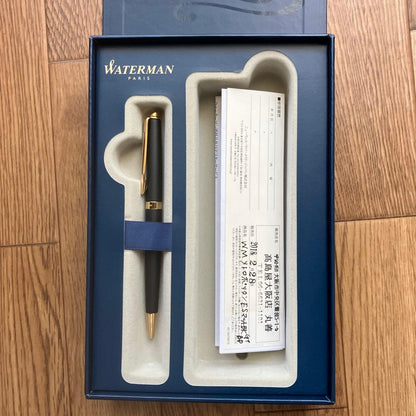 Waterman Metropolitan ballpoint pen with matte black body and gold trim lying on a white background