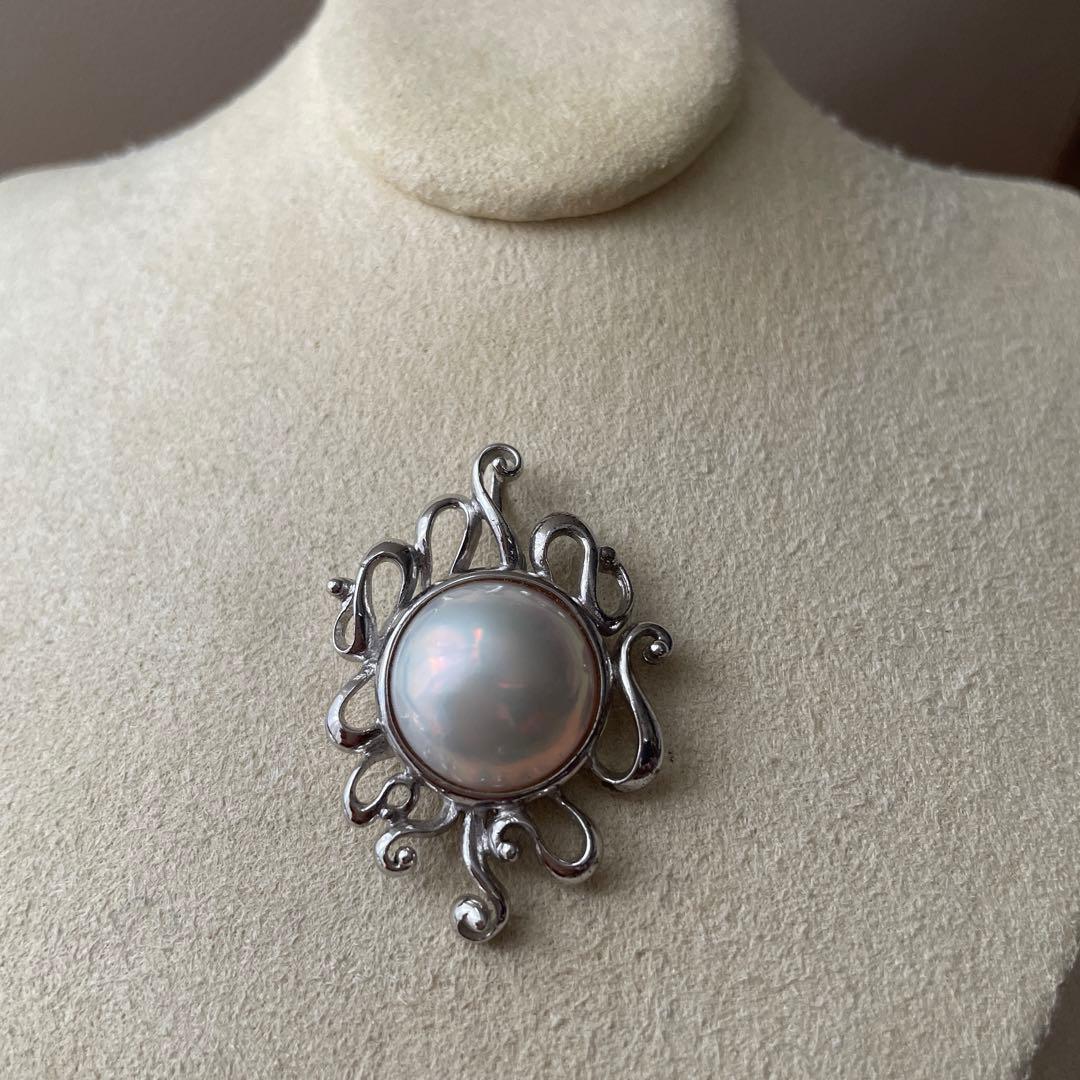 Tasaki pearl pendant necklace with round white pearl and silver chain on white background