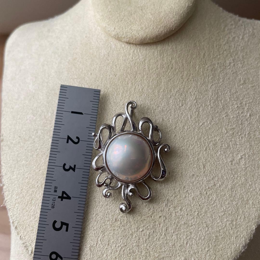 Tasaki pearl pendant necklace with round white pearl and silver chain on white background