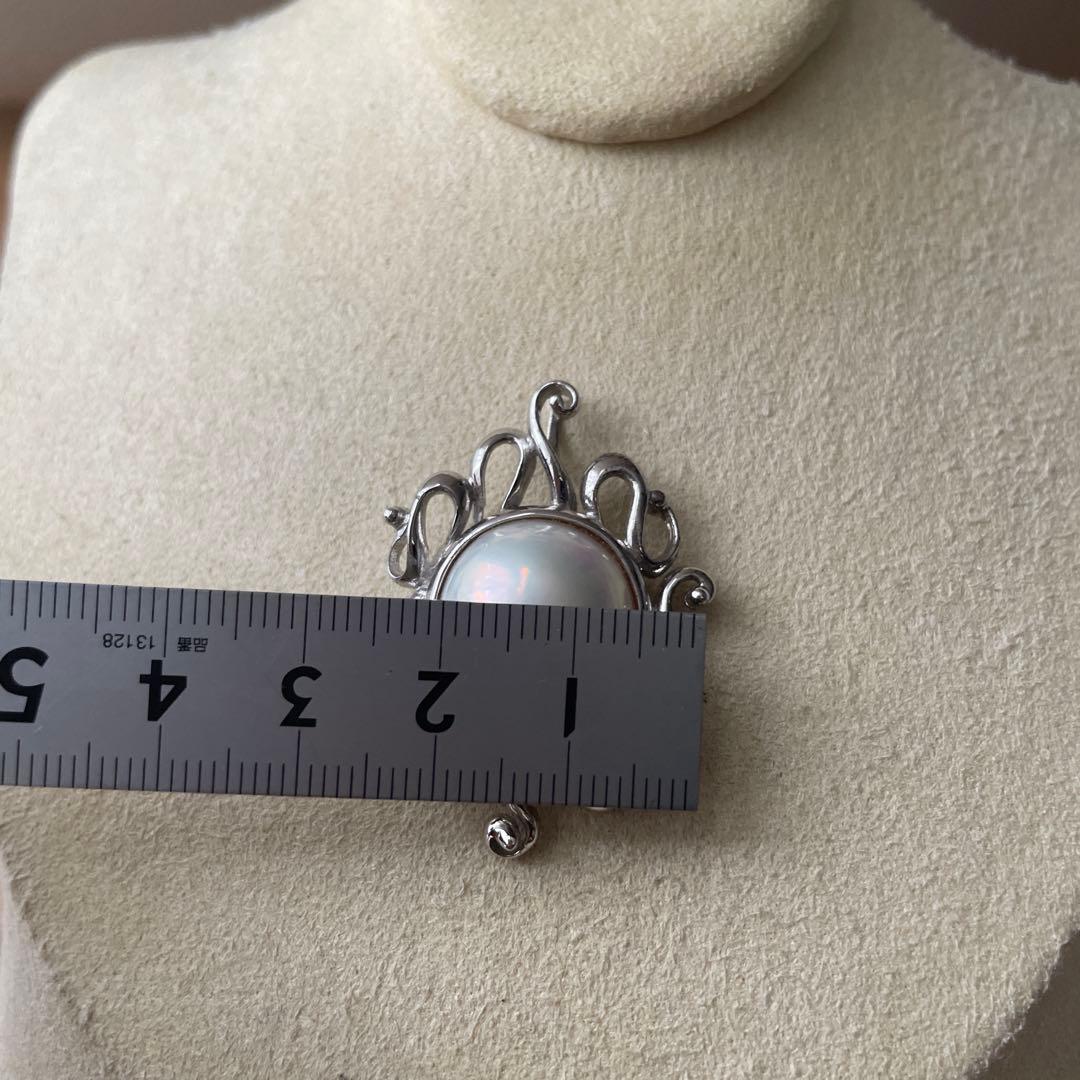 Tasaki pearl pendant necklace with round white pearl and silver chain on white background