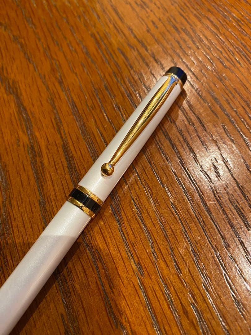 Pilot ballpoint pen with white metal body, gold trim, and blue top shown on a white background