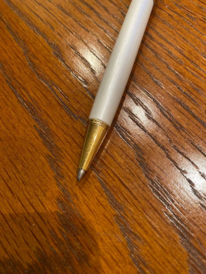 Pilot ballpoint pen with white metal body, gold trim, and blue top shown on a white background