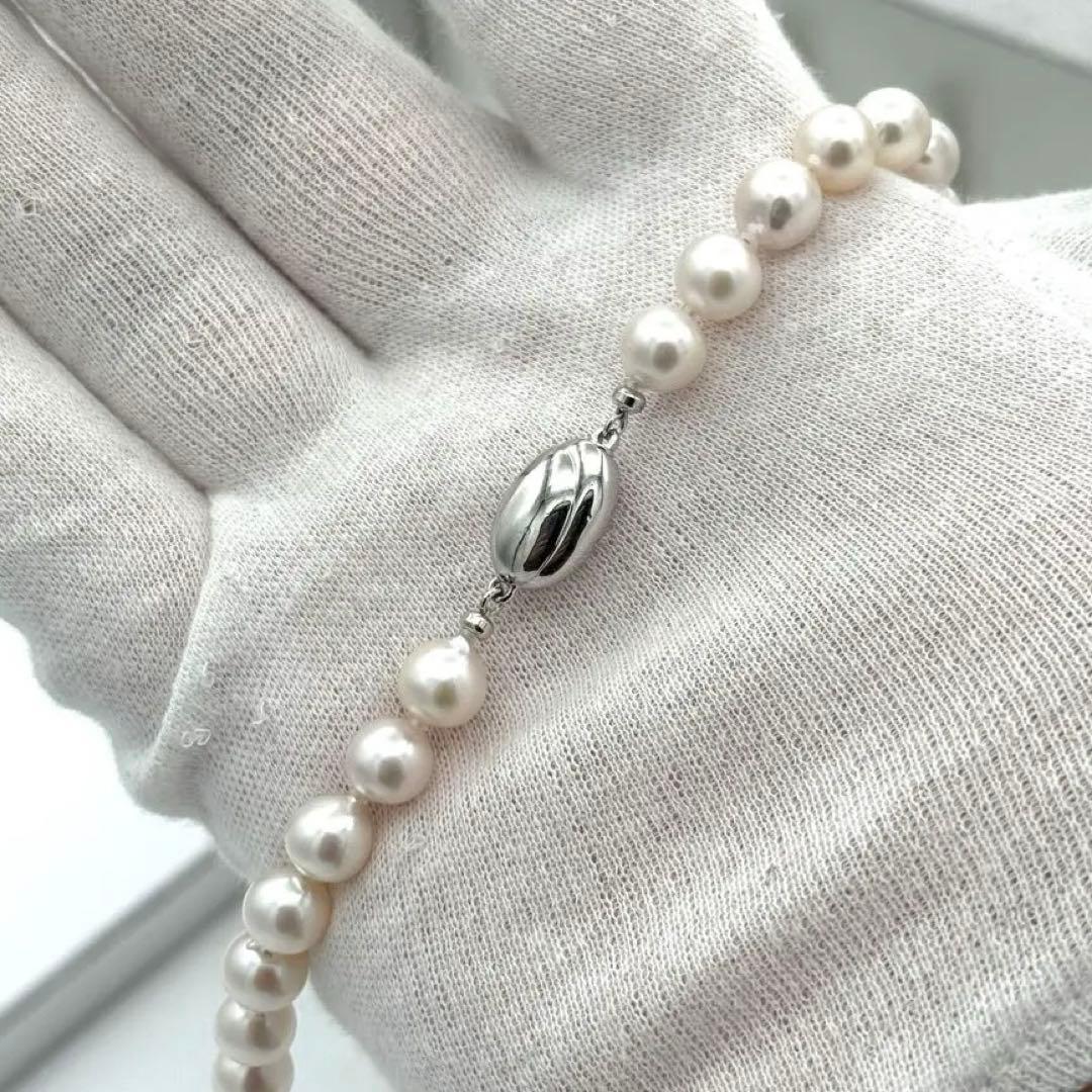 Akoya pearl necklace with 8.0mm-8.5mm pearls, 80cm length, white lustrous pearls on a display