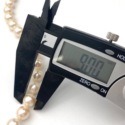 White Akoya pearl necklace and matching earrings with 8.5-9mm round pearls displayed on a white background