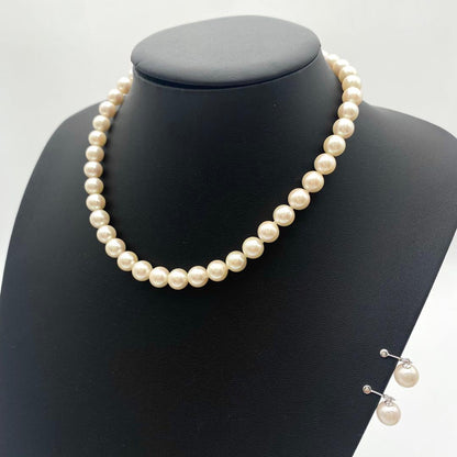 White Akoya pearl necklace and matching earrings with 8.5-9mm round pearls displayed on a white background