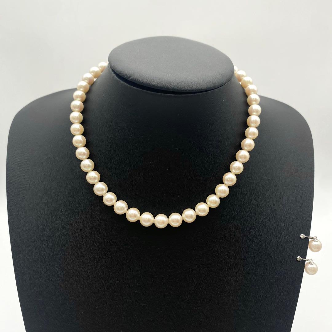 White Akoya pearl necklace and matching earrings with 8.5-9mm round pearls displayed on a white background
