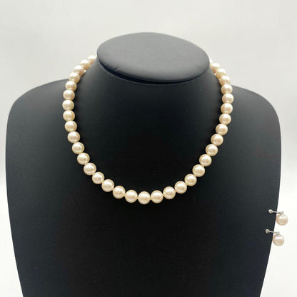 White Akoya pearl necklace and matching earrings with 8.5-9mm round pearls displayed on a white background