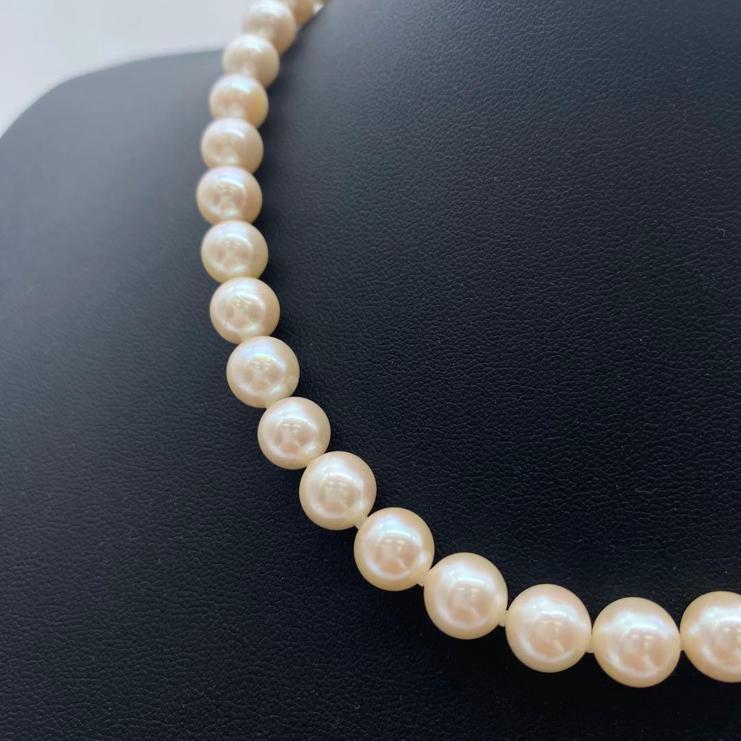 White Akoya pearl necklace and matching earrings with 8.5-9mm round pearls displayed on a white background