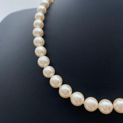 White Akoya pearl necklace and matching earrings with 8.5-9mm round pearls displayed on a white background