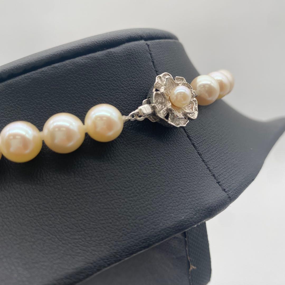 White Akoya pearl necklace and matching earrings with 8.5-9mm round pearls displayed on a white background