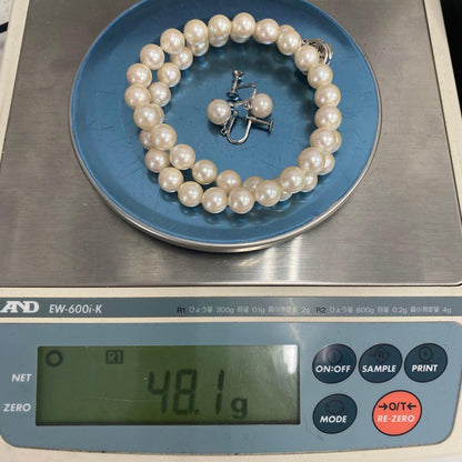 White Akoya pearl necklace and matching earrings with 8.5-9mm round pearls displayed on a white background