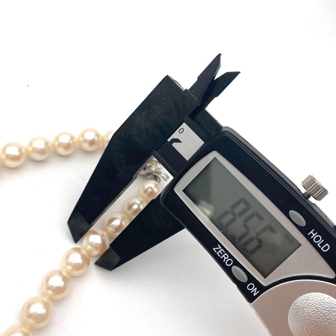 White Akoya pearl necklace and matching earrings with 8.5-9mm round pearls displayed on a white background