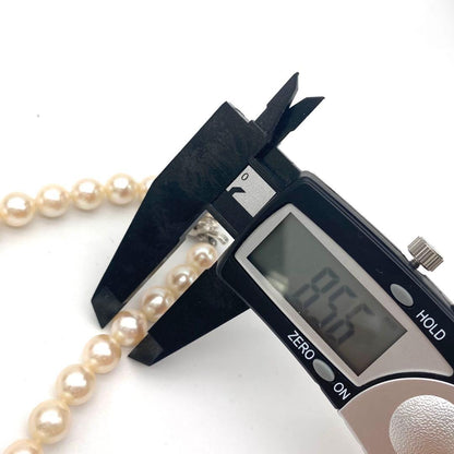 White Akoya pearl necklace and matching earrings with 8.5-9mm round pearls displayed on a white background