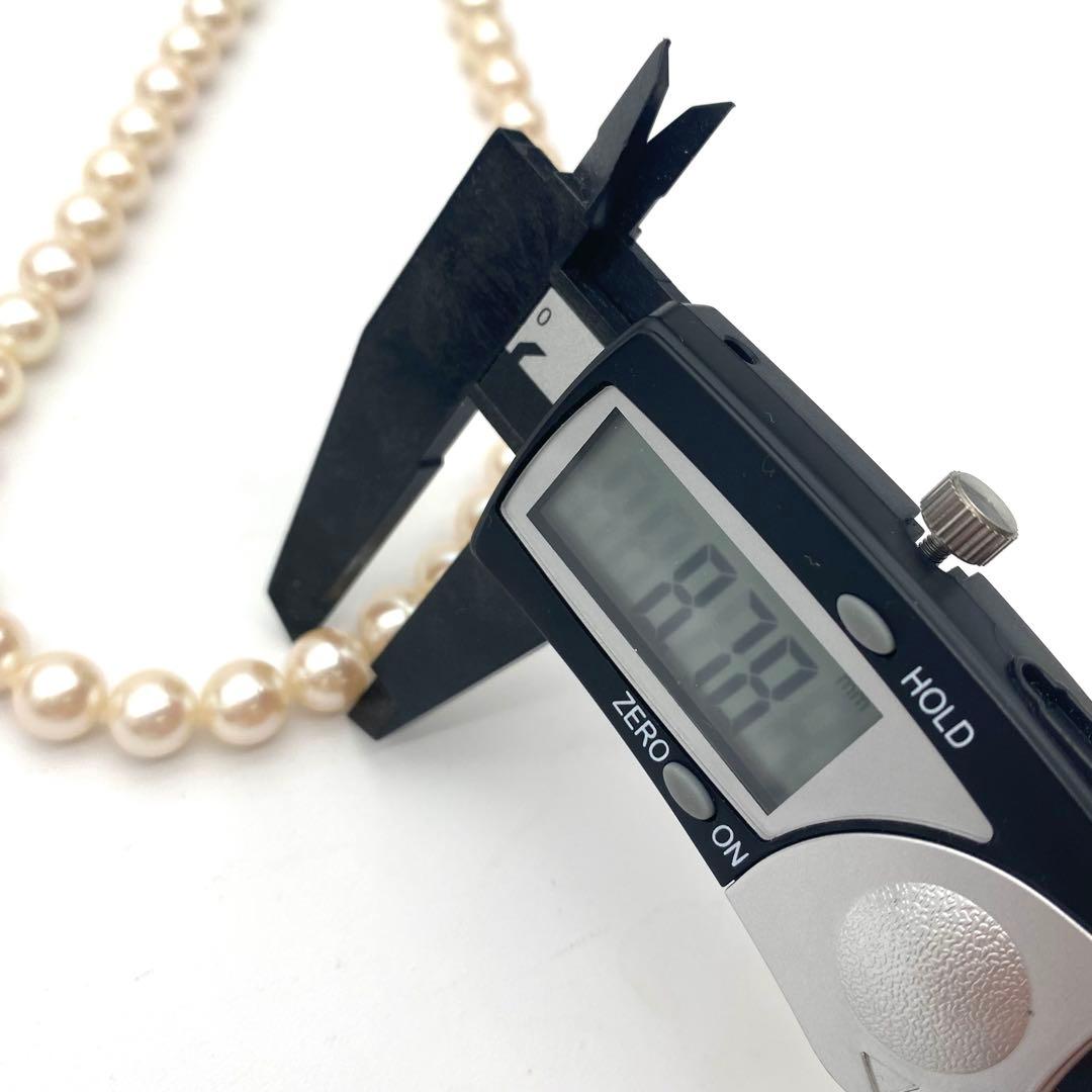 White Akoya pearl necklace and matching earrings with 8.5-9mm round pearls displayed on a white background