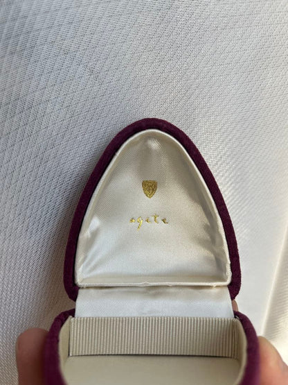 Agete Laurel Leaf Necklace in gold metal displayed with its case on a white background