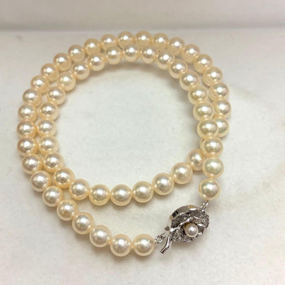 Akoya pearl necklace with 7.24mm white pearls and silver clasp on a white background