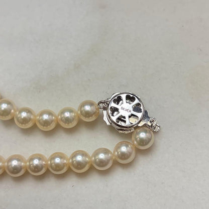 Akoya pearl necklace with 7.24mm white pearls and silver clasp on a white background