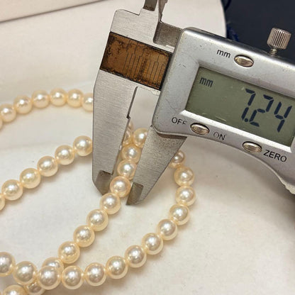 Akoya pearl necklace with 7.24mm white pearls and silver clasp on a white background