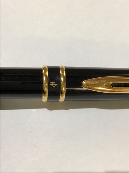 Waterman Paris black and gold ballpoint pen with leather case on white background
