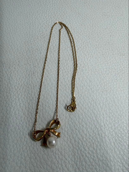 MIKIMOTO K18 yellow gold ribbon necklace featuring a single pearl pendant