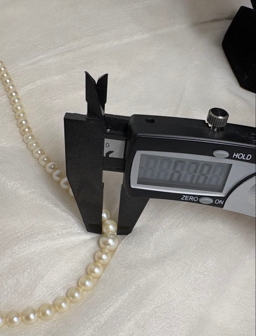 Mikimoto pearl necklace with white gold 14WG chain displayed alongside dedicated storage case