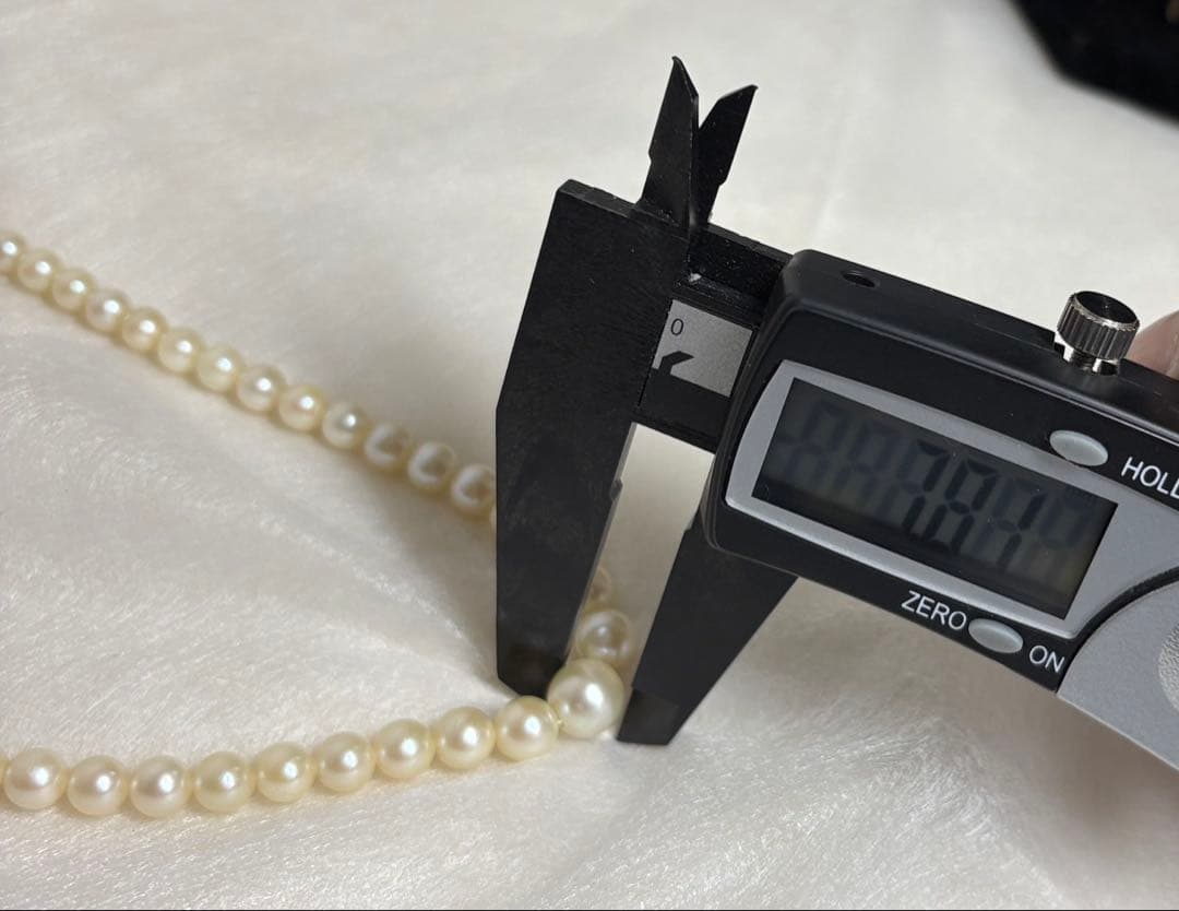 Mikimoto pearl necklace with white gold 14WG chain displayed alongside dedicated storage case