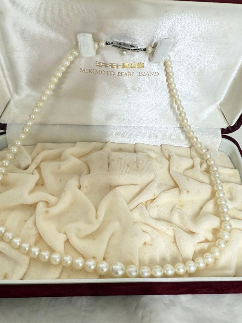 Mikimoto pearl necklace with white gold 14WG chain displayed alongside dedicated storage case