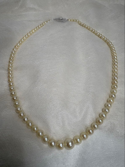 Mikimoto pearl necklace with white gold 14WG chain displayed alongside dedicated storage case