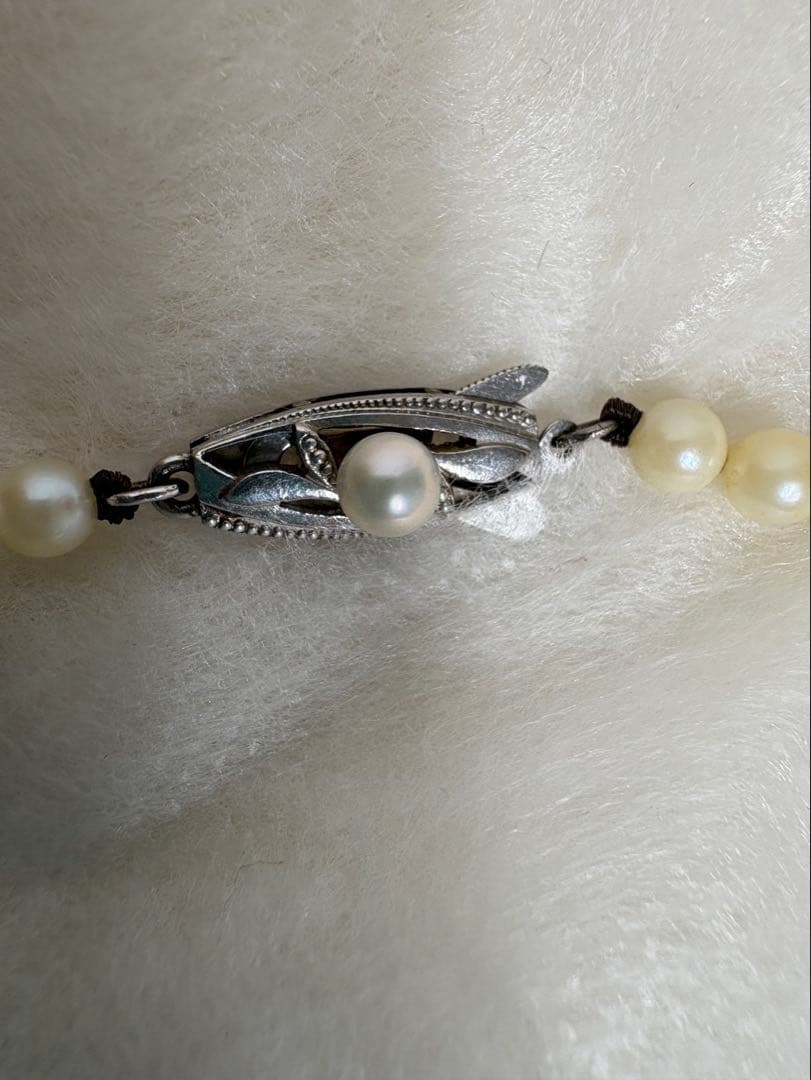 Mikimoto pearl necklace with white gold 14WG chain displayed alongside dedicated storage case