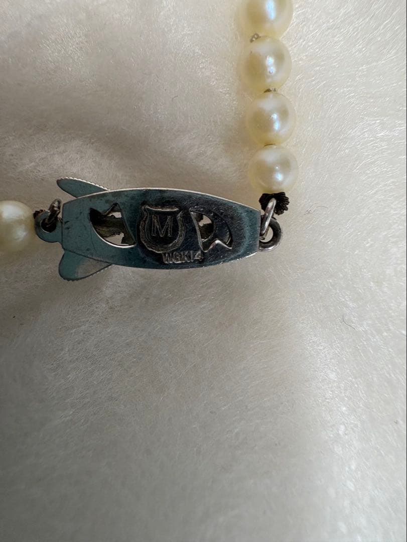Mikimoto pearl necklace with white gold 14WG chain displayed alongside dedicated storage case