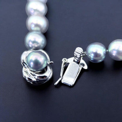 Tasaki Akoya pearl necklace and earrings set with 7mm round pearls and silver clasp on white background