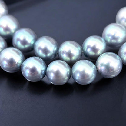 Tasaki Akoya pearl necklace and earrings set with 7mm round pearls and silver clasp on white background