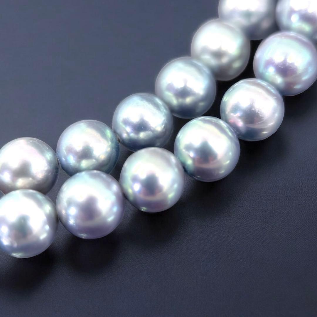 Tasaki Akoya pearl necklace and earrings set with 7mm round pearls and silver clasp on white background