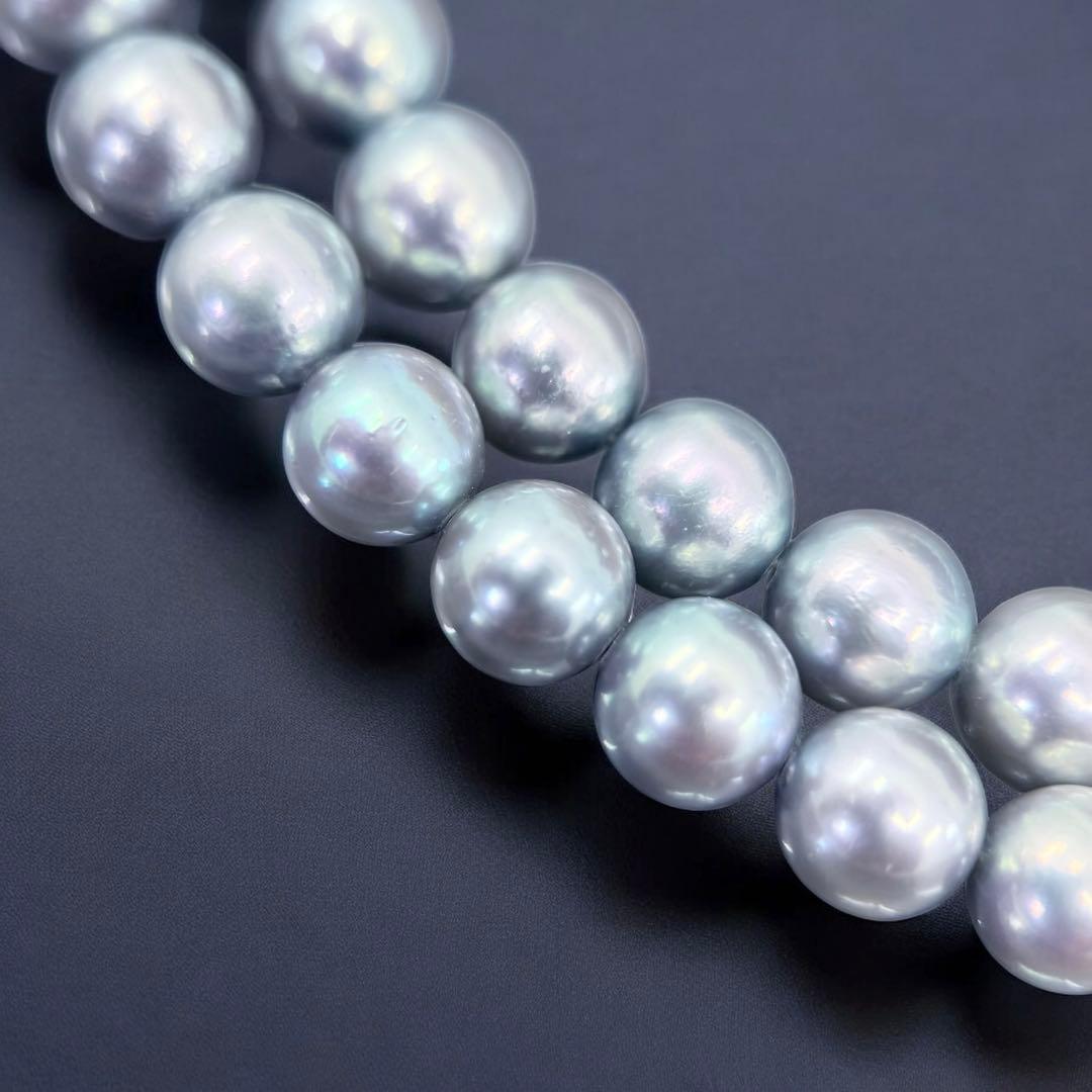 Tasaki Akoya pearl necklace and earrings set with 7mm round pearls and silver clasp on white background