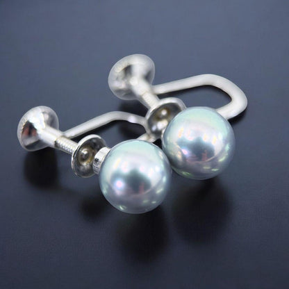 Tasaki Akoya pearl necklace and earrings set with 7mm round pearls and silver clasp on white background