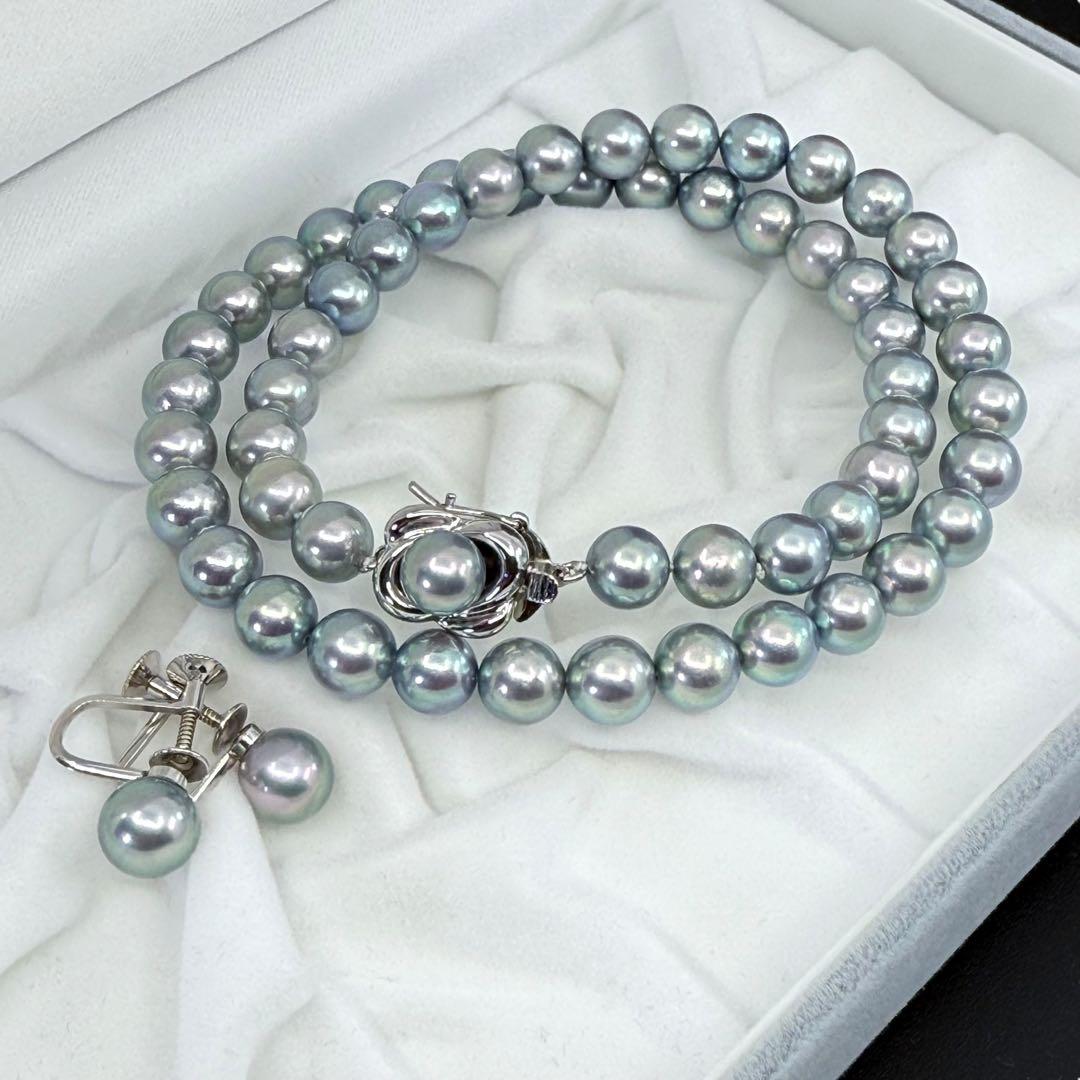 Tasaki Akoya pearl necklace and earrings set with 7mm round pearls and silver clasp on white background