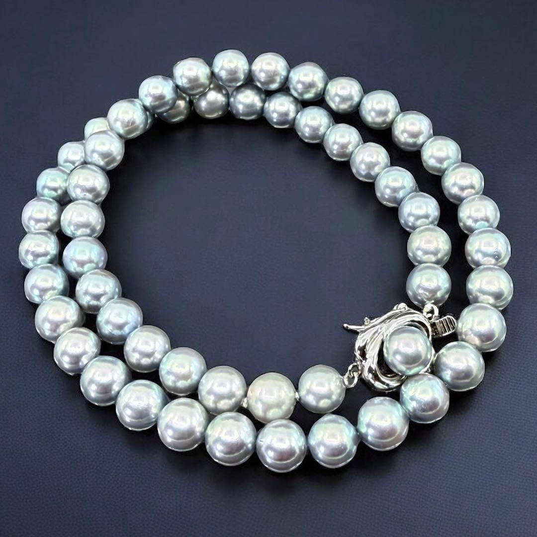 Tasaki Akoya pearl necklace and earrings set with 7mm round pearls and silver clasp on white background