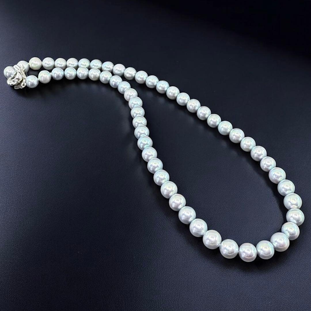 Tasaki Akoya pearl necklace and earrings set with 7mm round pearls and silver clasp on white background