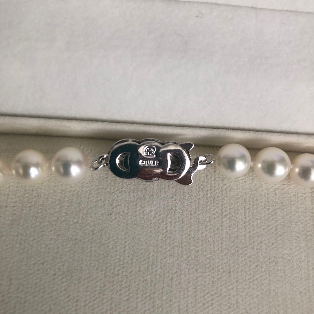 Elegant pearl necklace featuring 57 pearls and a silver clasp on a white background