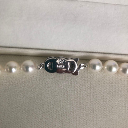 Elegant pearl necklace featuring 57 pearls and a silver clasp on a white background