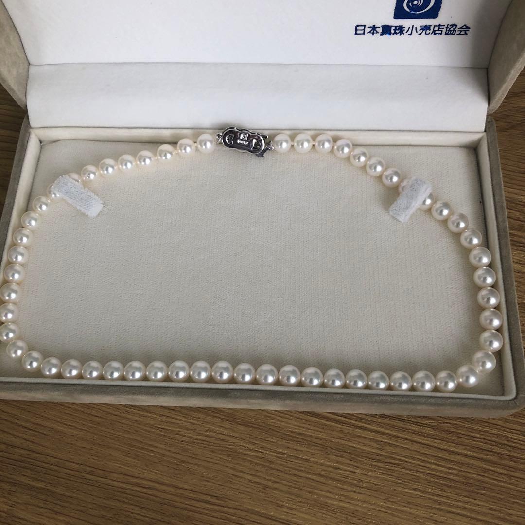 Elegant pearl necklace featuring 57 pearls and a silver clasp on a white background