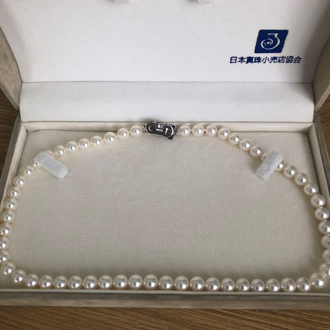 Elegant pearl necklace featuring 57 pearls and a silver clasp on a white background