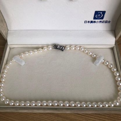 Elegant pearl necklace featuring 57 pearls and a silver clasp on a white background